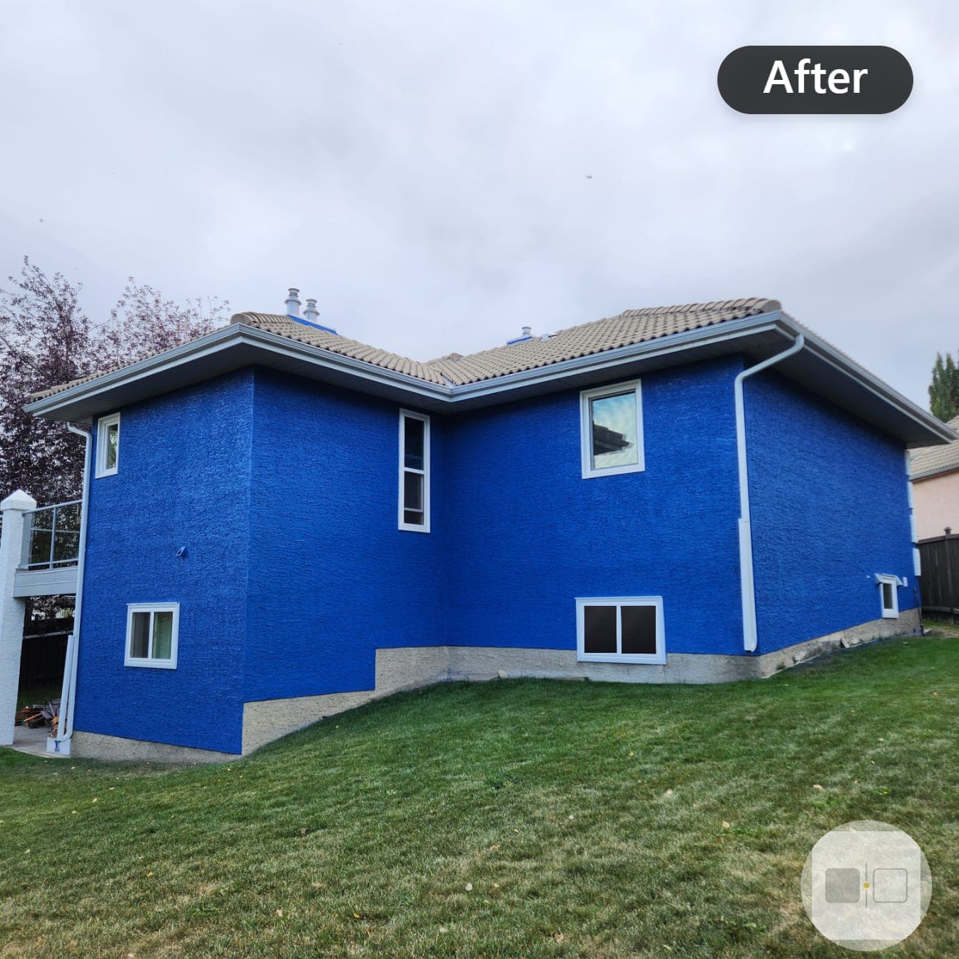 The same house after painting, stucco finished in a bold blue