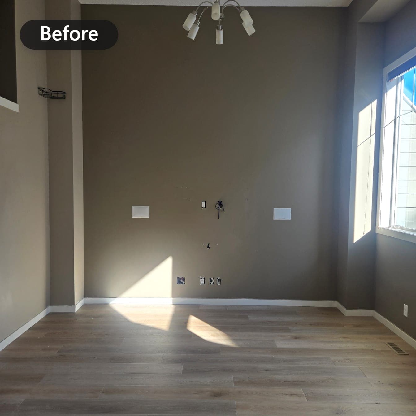 Room with dark charcoal walls before repainting, bare walls and wood floor